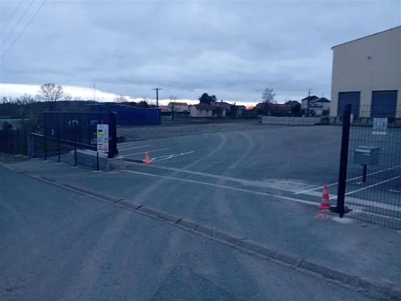 Entrée du parking du Humeau, avec clôture et portail ouvert